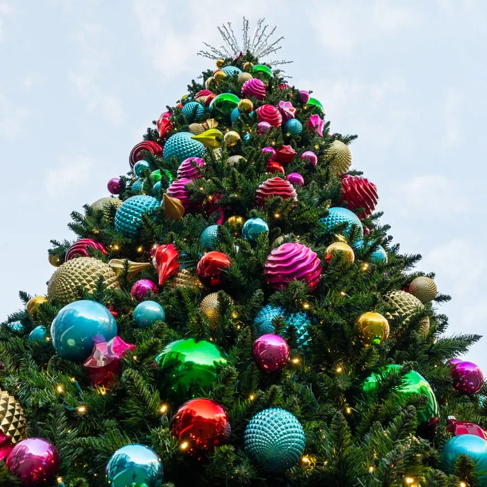 Decorated Christmas tree with colorful ornaments against a clear sky