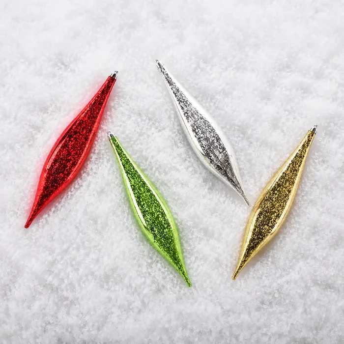 Four glittery Christmas ornament pendants shaped like stylized leaves, shown on a white textured background. The ornaments are in red, green, silver, and gold glitter finishes.